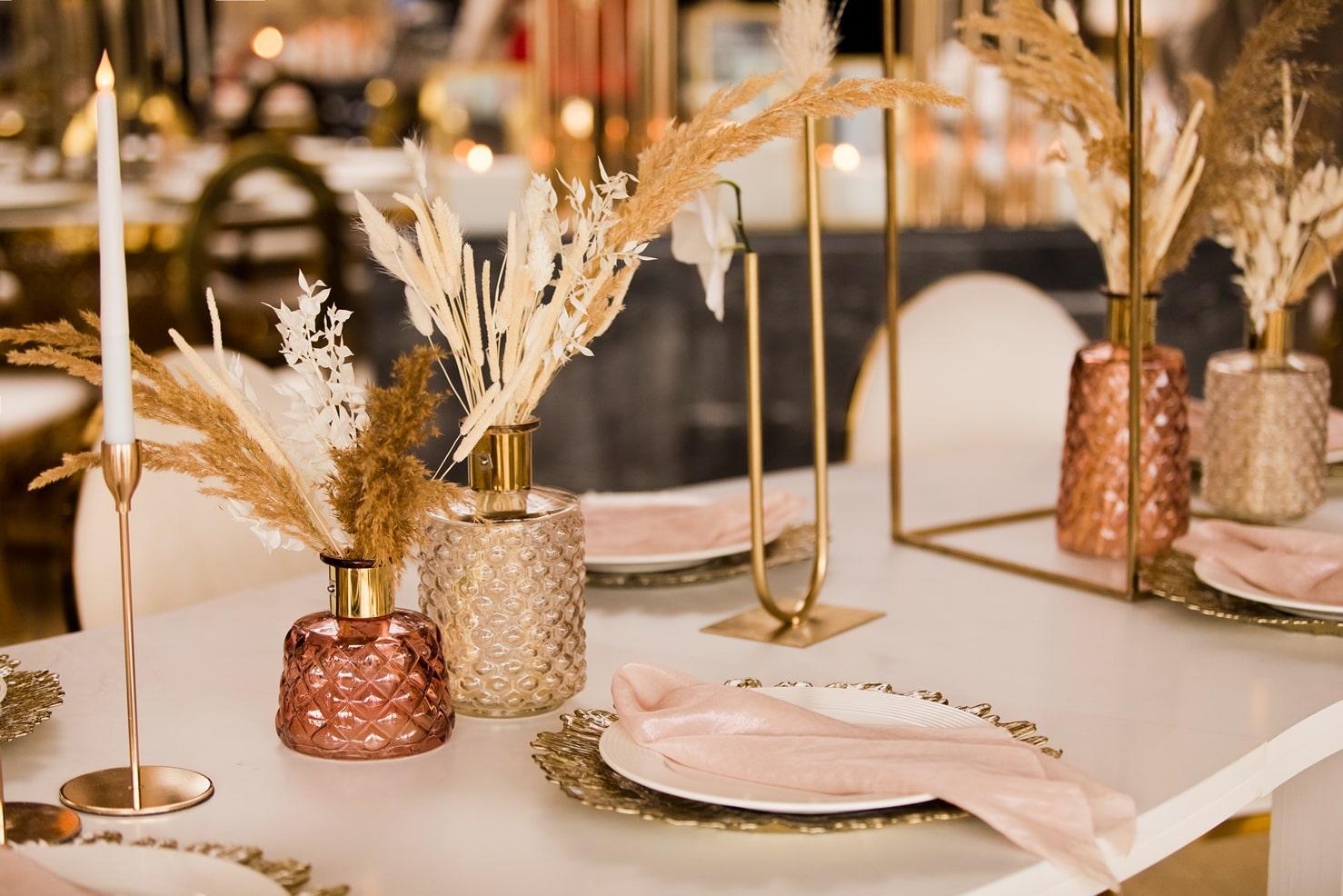 Table de mariage dressée avec fleurs séchées, bougies et verrerie dorée